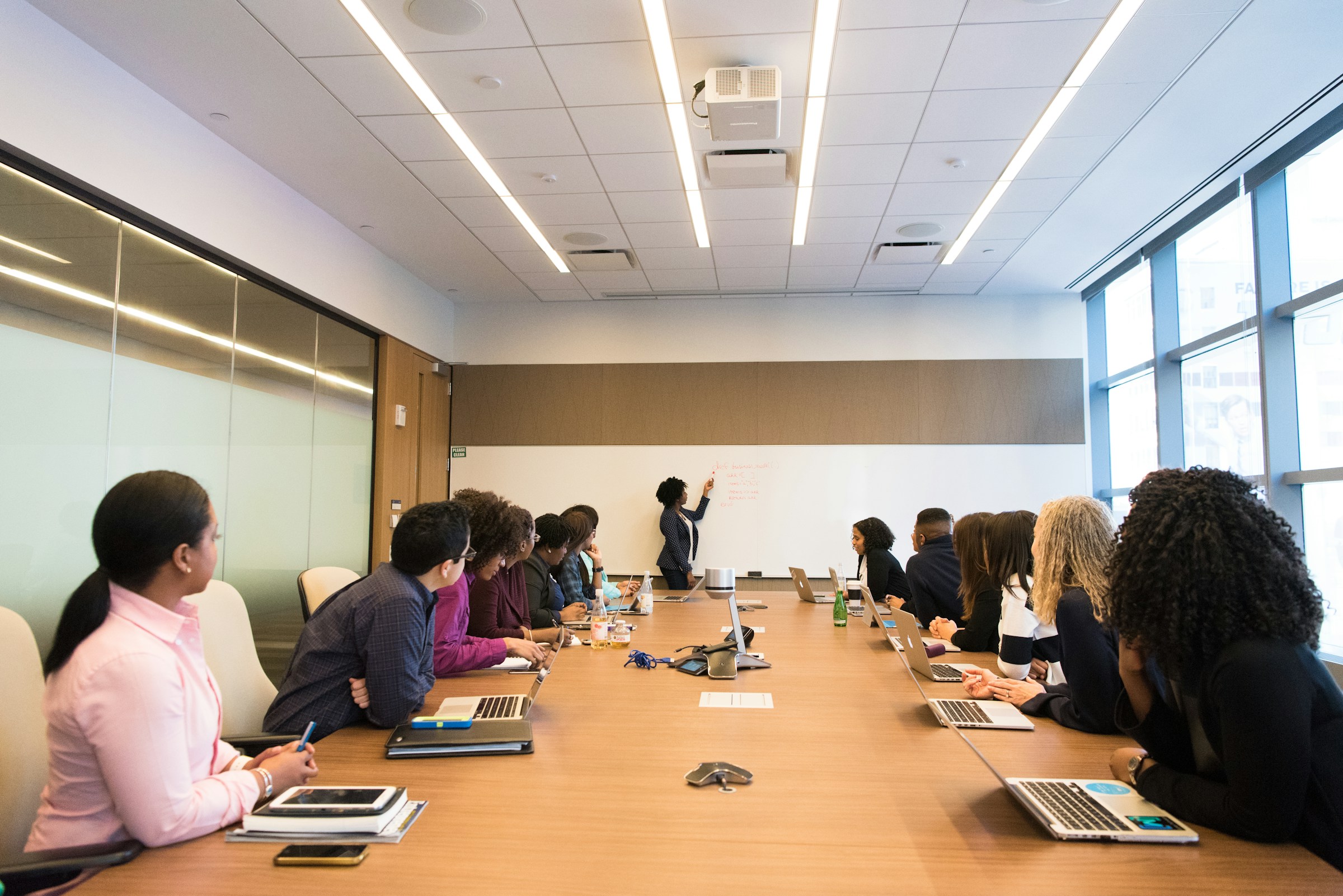 Colleagues listening to a woman speaking in a workplace meeting