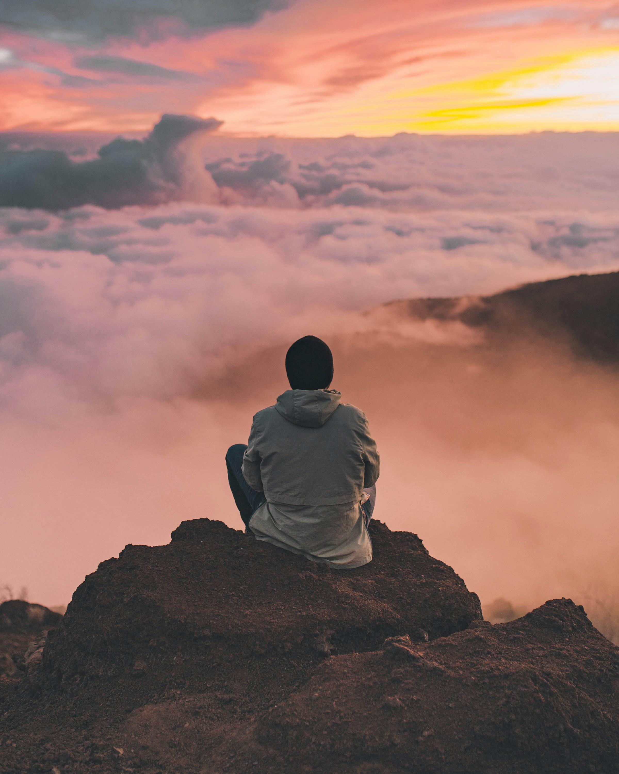 Person overlooking a mountain landscape at sunrise